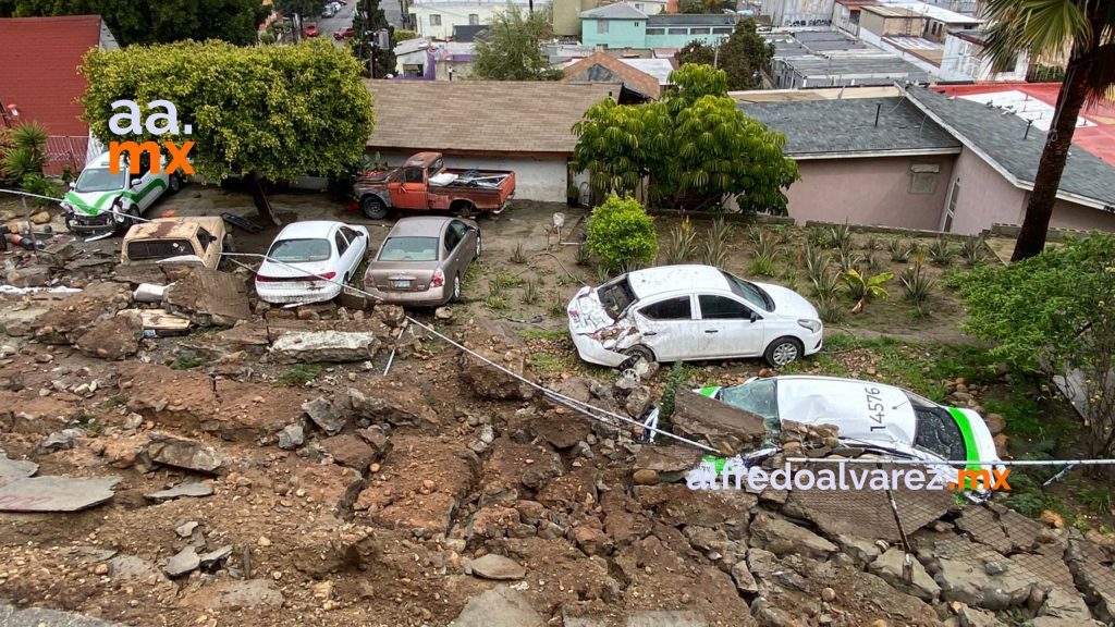Derrumbe de una barda deja daños en seis vehículos