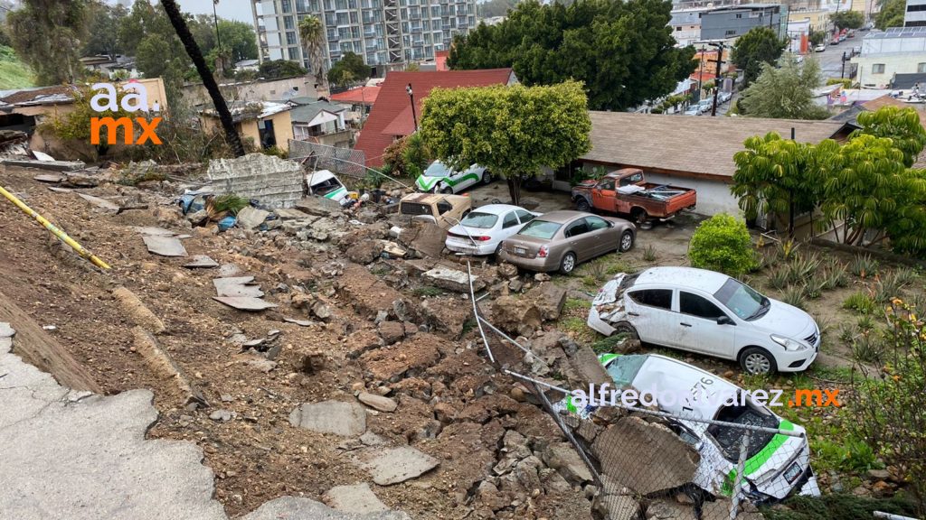 Derrumbe de una barda deja daños en seis vehículos