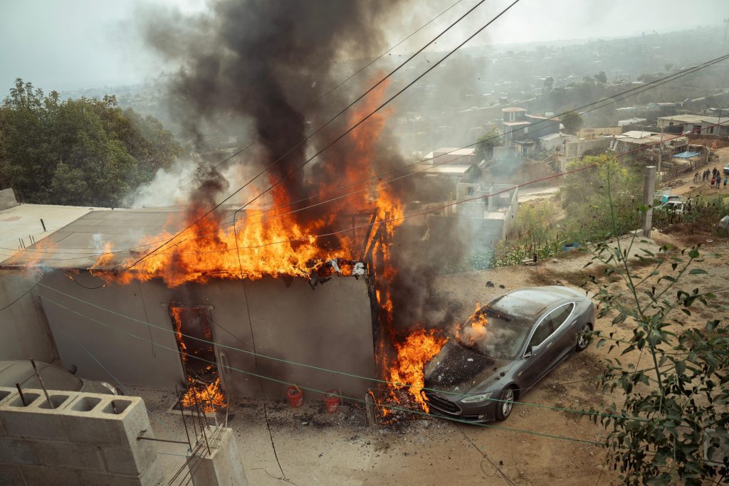 Se cuelgan de poste de luz para cargar un Tesla y se incendia
