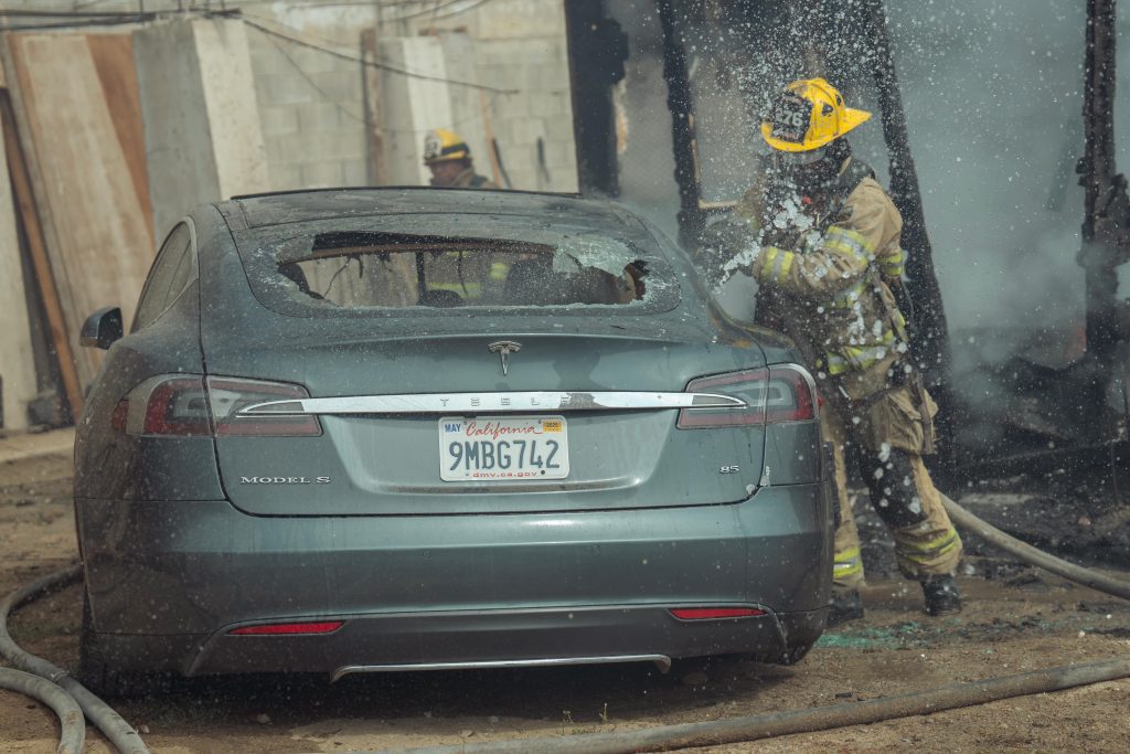 Se cuelgan de poste de luz para cargar un Tesla y se incendia
